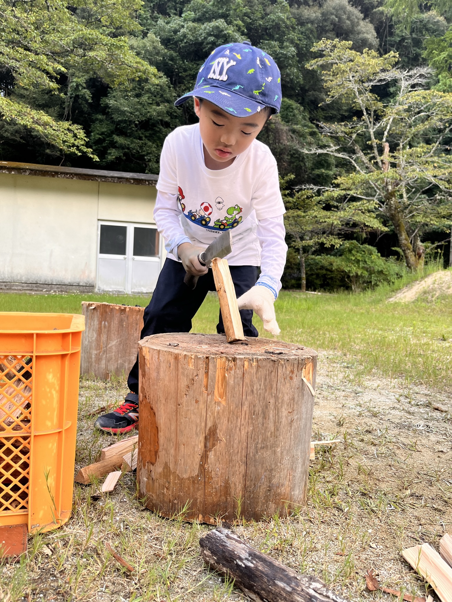 屋外で薪割りに挑戦する子ども