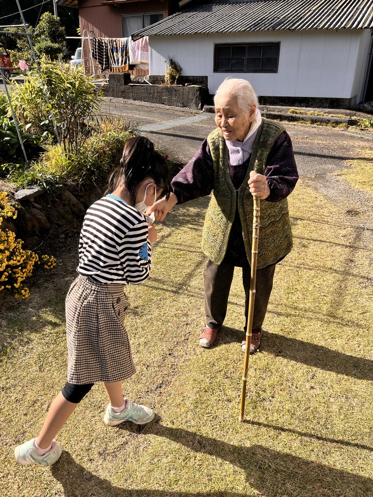 高齢者と子どもが会話する地域の風景